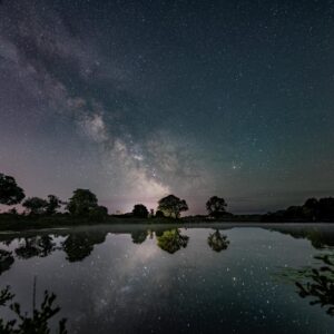 The Milky way reflected in the still waters of a reservoir near Penzance, Cornwall.